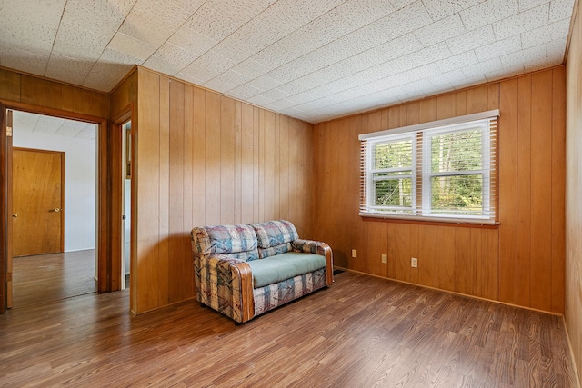 sitting room featuring wood walls and hardwood / wood-style flooring