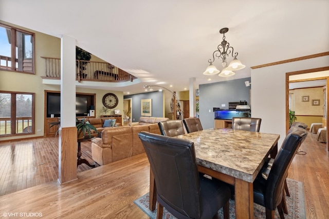 dining area featuring light wood-type flooring and an inviting chandelier