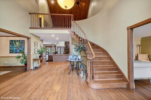 staircase featuring wood-type flooring and a towering ceiling