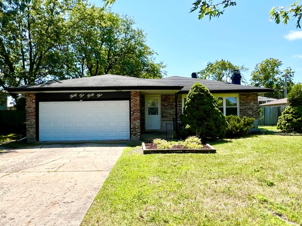 ranch-style house featuring a front yard and a garage