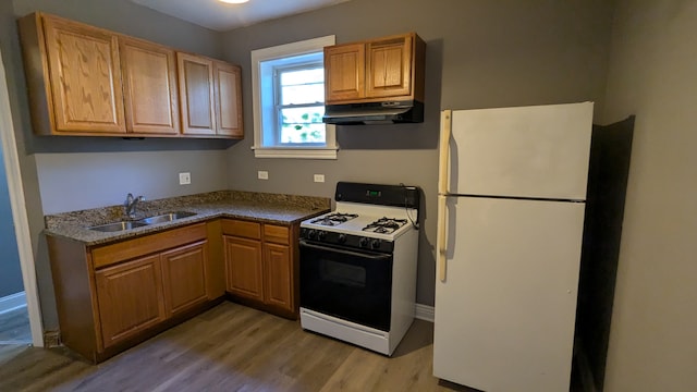 kitchen with white appliances, sink, and light wood-type flooring