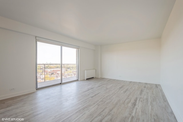 unfurnished room featuring light wood-type flooring and radiator