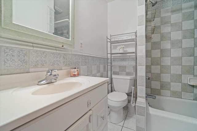 full bathroom with vanity, tiled shower / bath, tile walls, tile patterned flooring, and toilet