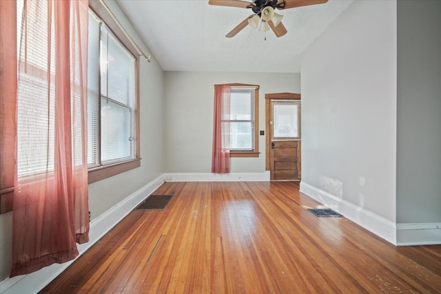 unfurnished room with hardwood / wood-style flooring, ceiling fan, and a textured ceiling