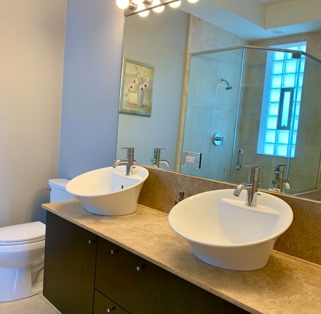 bathroom featuring walk in shower, vanity, and toilet