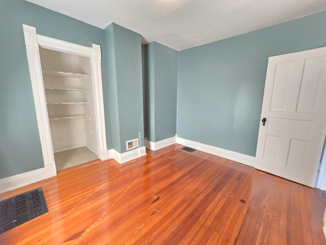 unfurnished bedroom with hardwood / wood-style flooring and a closet