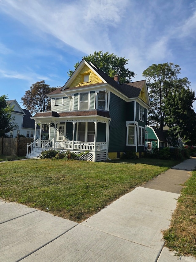 victorian house featuring a front lawn and covered porch