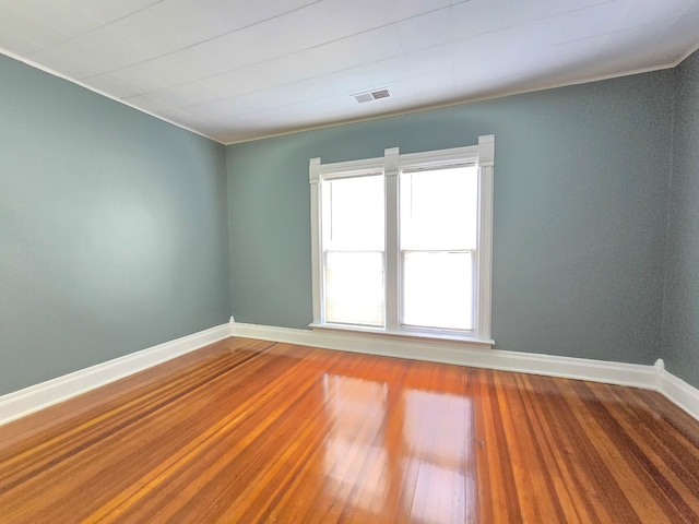 unfurnished room with ornamental molding and hardwood / wood-style flooring