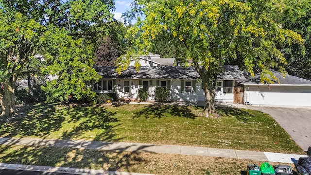 view of front of home with a front yard, a garage, and covered porch