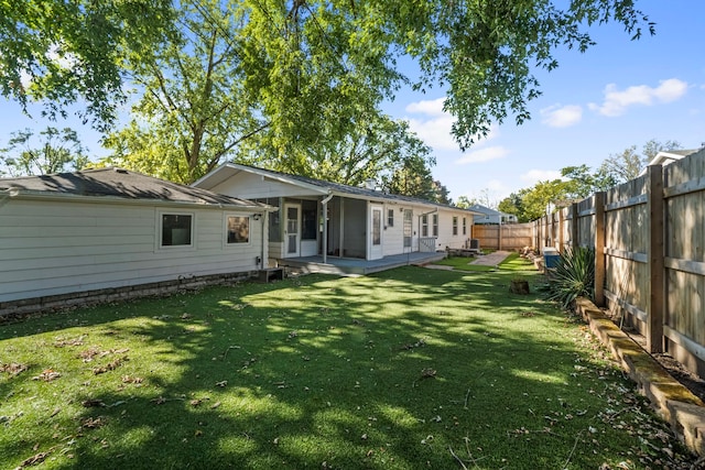 rear view of house with a yard and a patio area