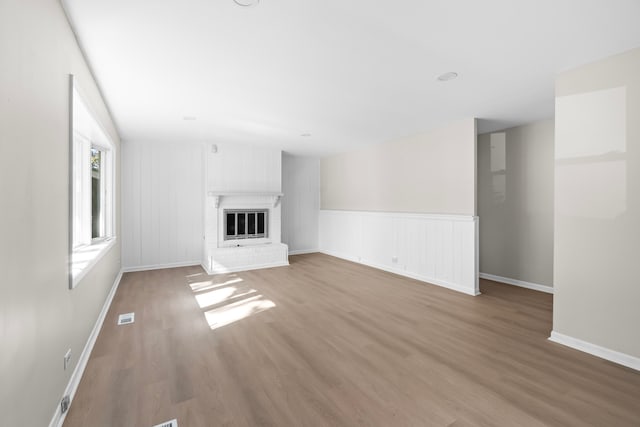 unfurnished living room featuring a fireplace and light hardwood / wood-style flooring