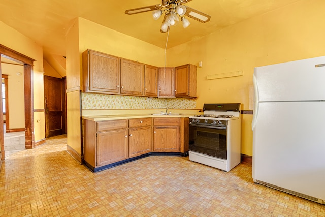 kitchen with ceiling fan, decorative backsplash, white appliances, sink, and vaulted ceiling