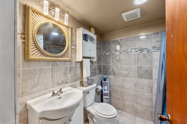 bathroom with tile walls, toilet, vanity, a shower with curtain, and tile patterned floors