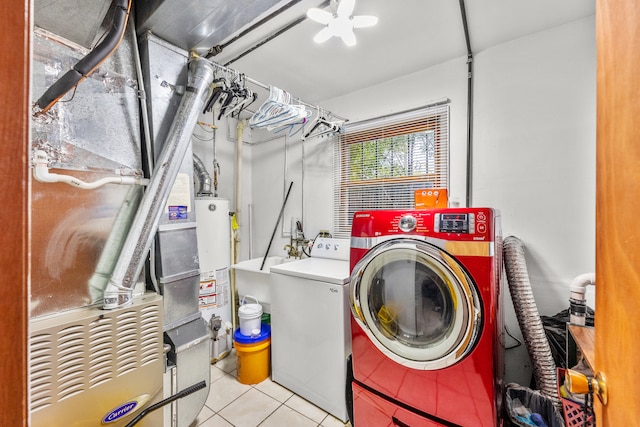 laundry area featuring washing machine and dryer, light tile patterned floors, and water heater