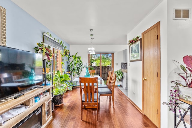 dining room featuring hardwood / wood-style floors and a notable chandelier