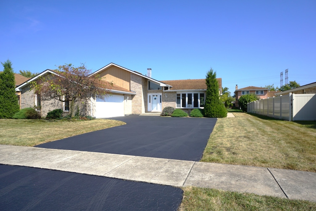 ranch-style house with a garage and a front lawn