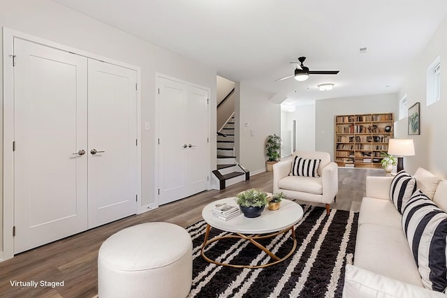 living room with stairway, baseboards, wood finished floors, and a ceiling fan