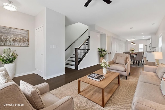 living room featuring ceiling fan, baseboards, stairs, recessed lighting, and wood finished floors