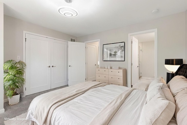 carpeted bedroom featuring a closet and visible vents