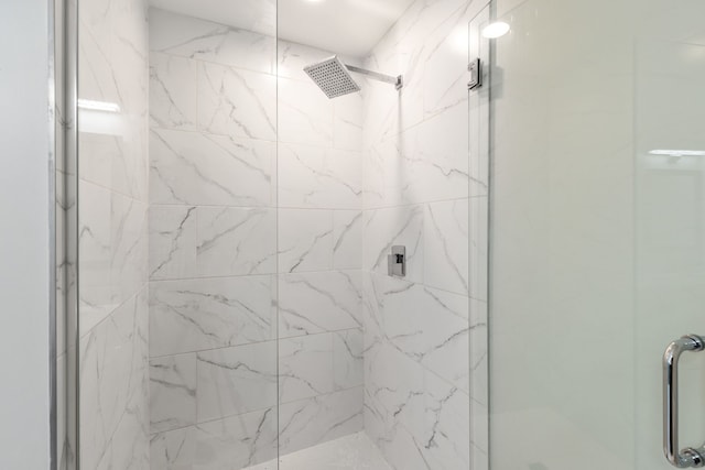 bathroom featuring a marble finish shower