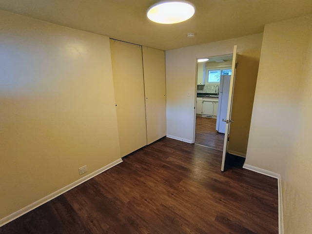 interior space featuring sink, white refrigerator, a closet, and dark hardwood / wood-style flooring