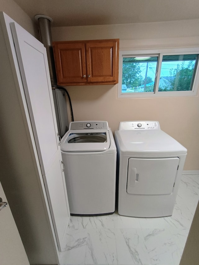 washroom with cabinets and washing machine and clothes dryer