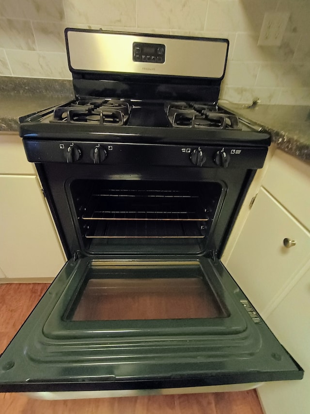 room details with black gas stove and white cabinetry