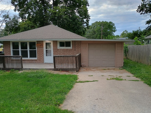 single story home with a garage and a front lawn