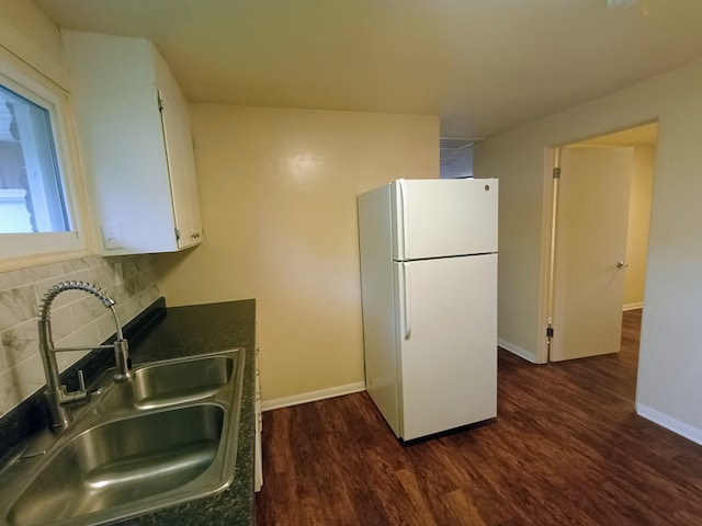 kitchen featuring sink, dark wood-type flooring, white cabinetry, white fridge, and decorative backsplash