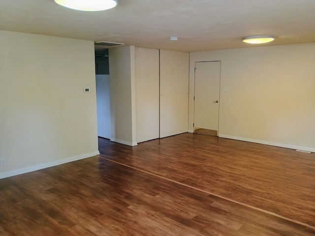 empty room with dark hardwood / wood-style flooring