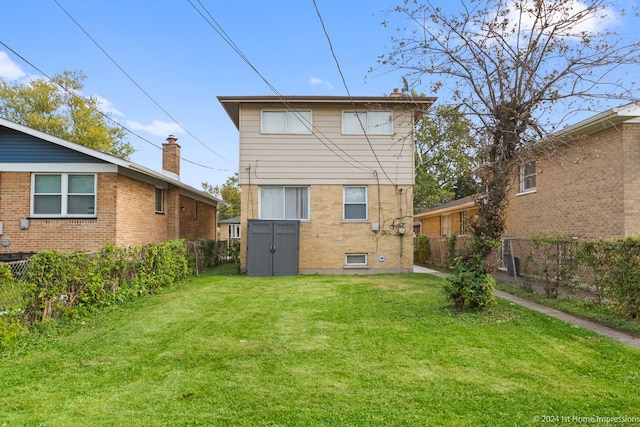 back of property with a yard and a storage unit