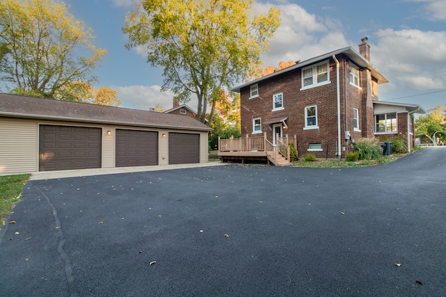 view of front of house with a garage and an outbuilding