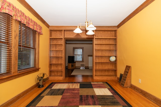 unfurnished dining area featuring ornamental molding, a chandelier, and dark hardwood / wood-style flooring