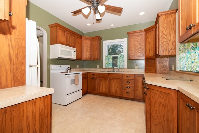 kitchen featuring ceiling fan, sink, and white appliances