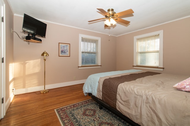 bedroom with crown molding, hardwood / wood-style flooring, and ceiling fan