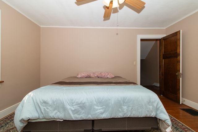 bedroom with ceiling fan, ornamental molding, and dark wood-type flooring