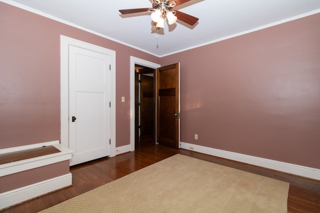 unfurnished bedroom featuring dark hardwood / wood-style floors, ornamental molding, and ceiling fan