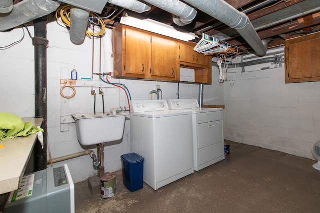 washroom featuring washing machine and clothes dryer, sink, and cabinets