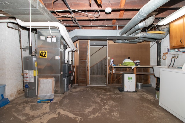 basement featuring water heater, washer / clothes dryer, and heating unit