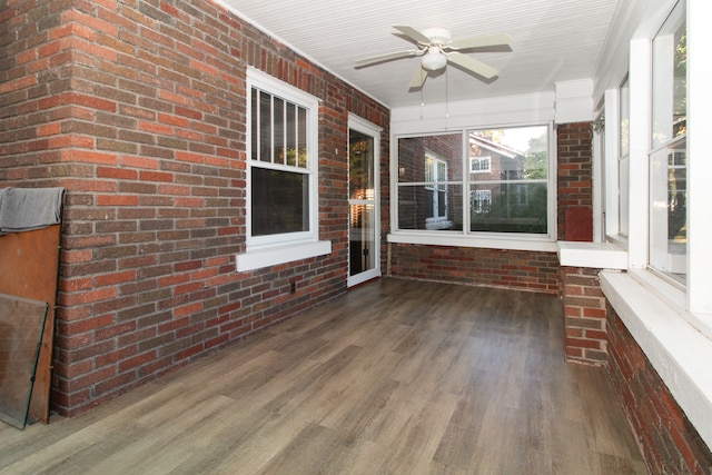 unfurnished sunroom featuring ceiling fan