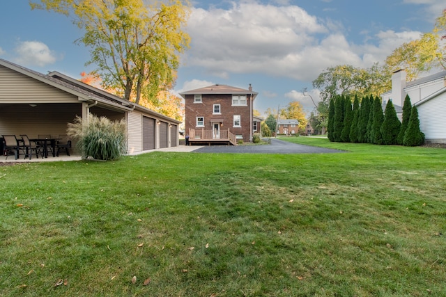 view of yard featuring a garage and a deck