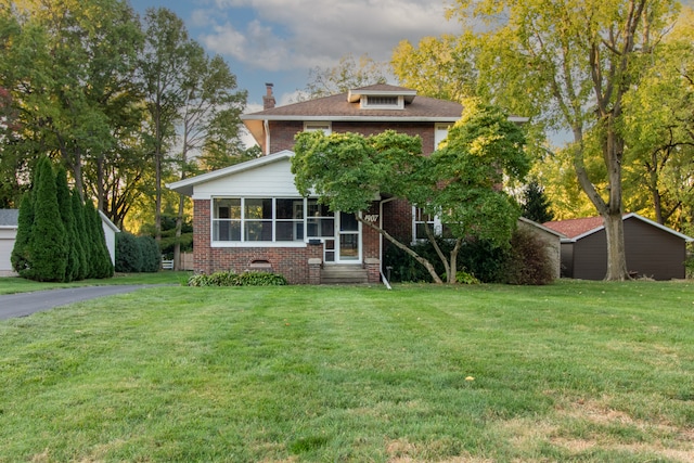 view of front facade featuring a sunroom and a front lawn