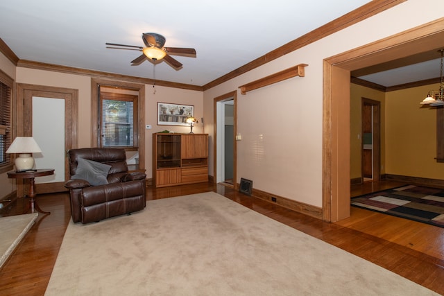 living room featuring ceiling fan, ornamental molding, and dark hardwood / wood-style flooring