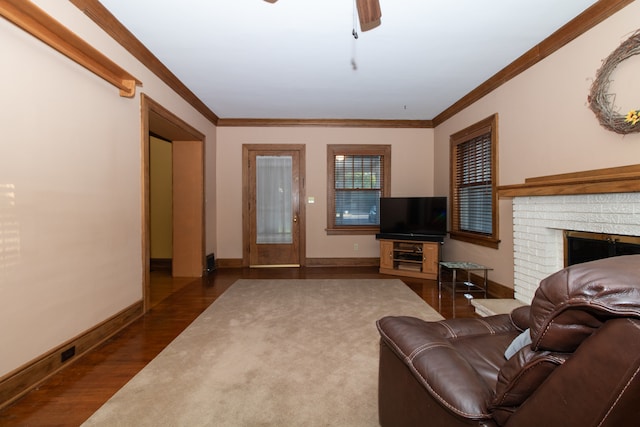 living room featuring a brick fireplace, crown molding, and dark hardwood / wood-style flooring