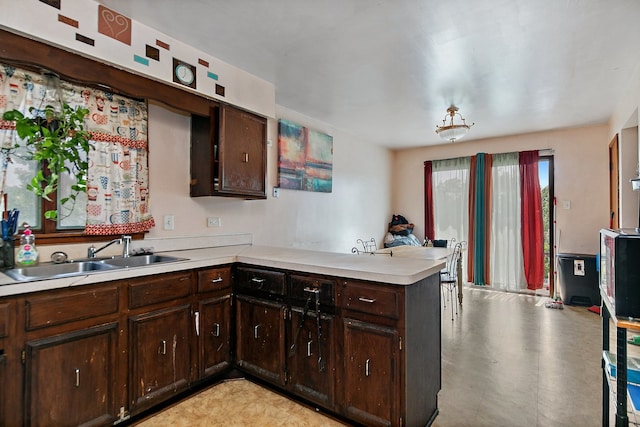 kitchen with dark brown cabinets, sink, and kitchen peninsula