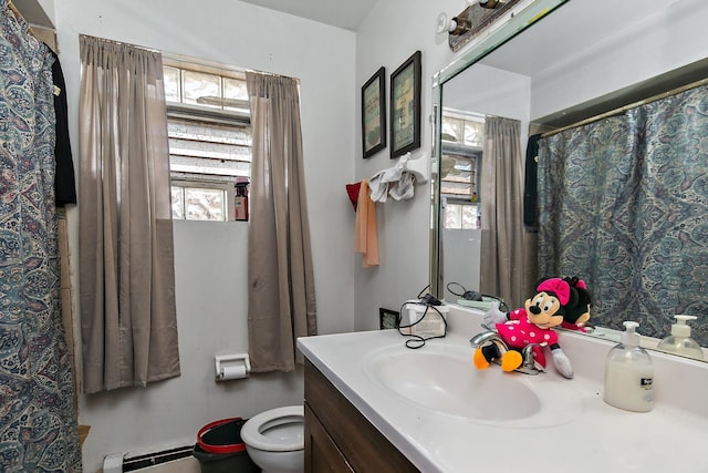 bathroom featuring vanity, toilet, and a baseboard heating unit