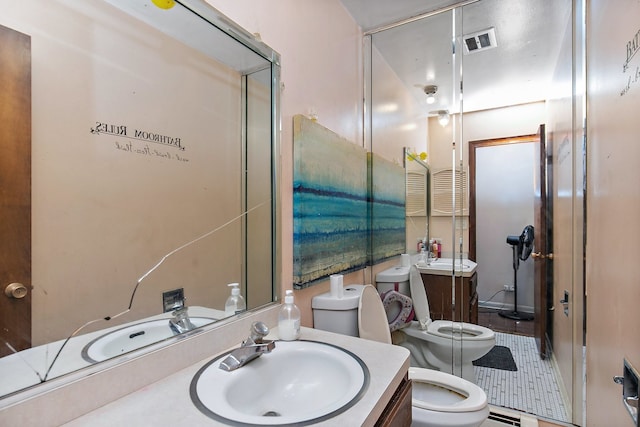 bathroom featuring a baseboard radiator, vanity, a shower with shower door, and toilet