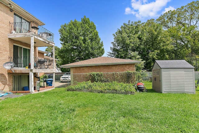 view of yard with a storage unit and a balcony