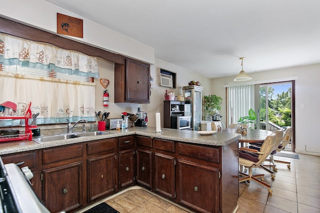 kitchen with dark brown cabinetry, sink, kitchen peninsula, hanging light fixtures, and light tile patterned floors