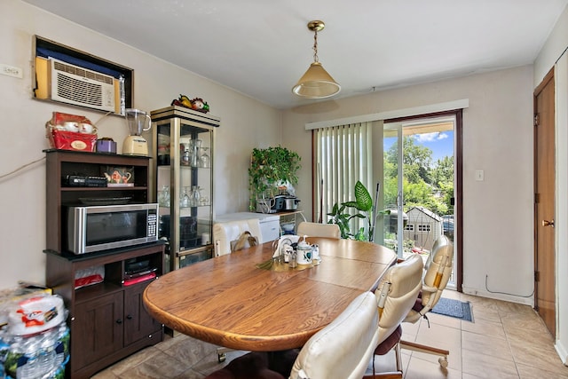 dining space featuring light tile patterned flooring and a wall mounted air conditioner